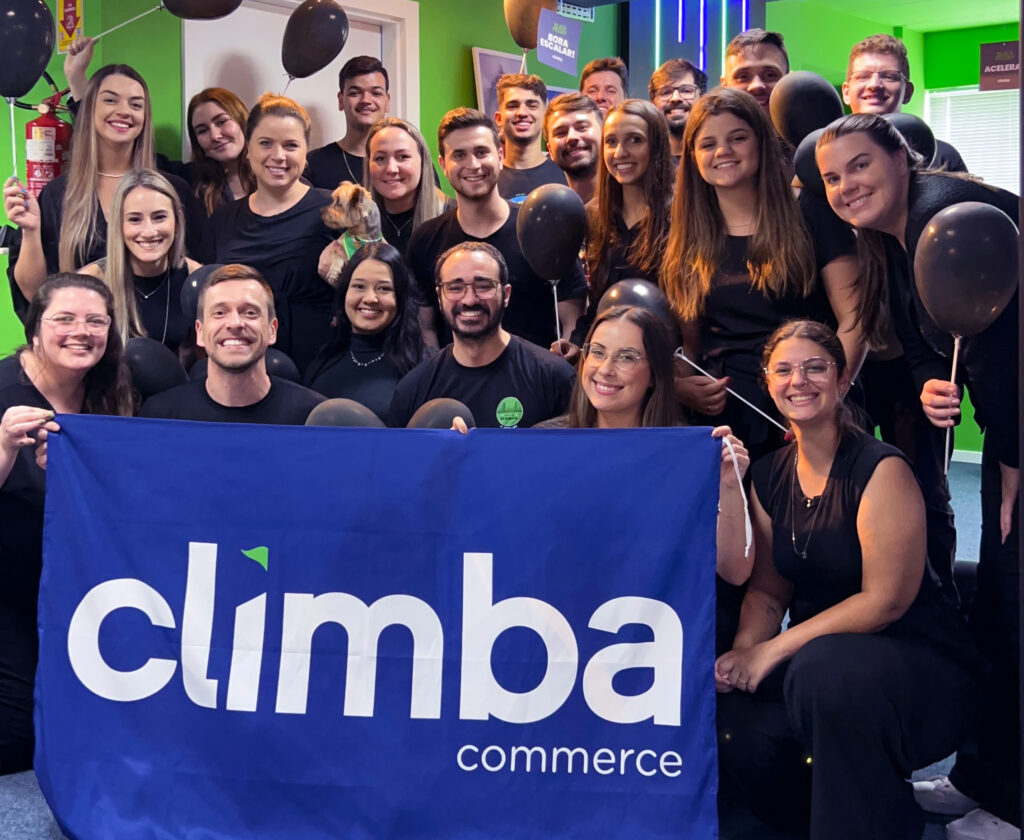 Equipe da Climba com roupa preta na temática de Black Friday com a bandeira na frente da Climba
